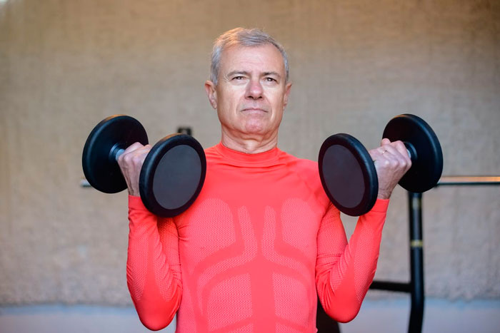 Hombre mayor ejercitando biceps