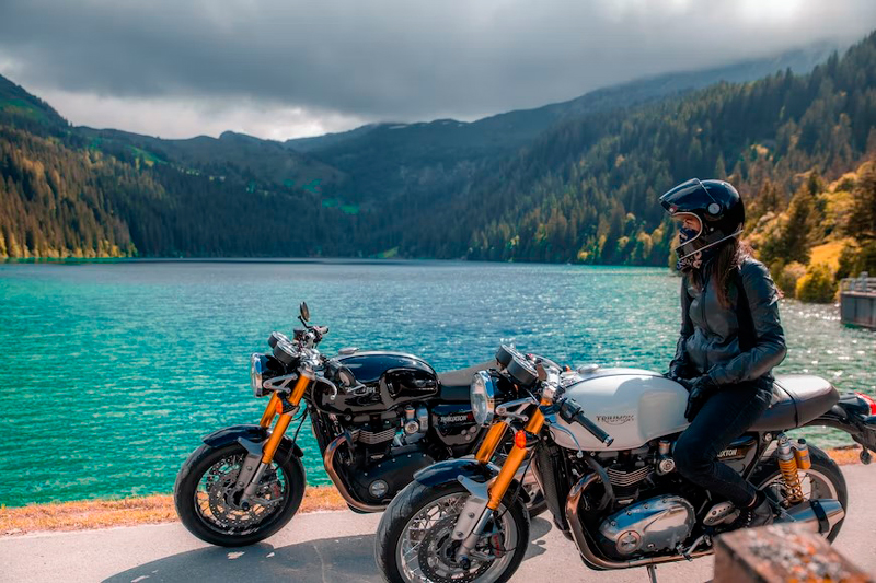 Mujer en una moto disfrutando de un paisaje