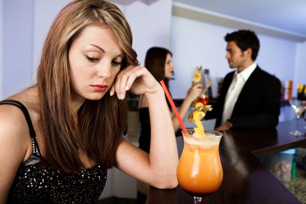 Mujer sola en un bar pensando en una ex pareja