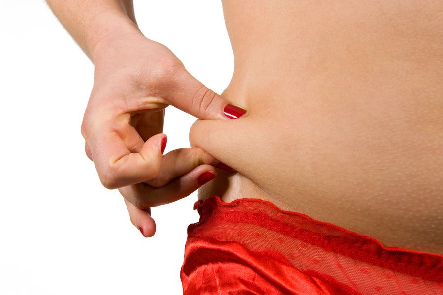 Pellizco sobre la piel al costado de la barriga. Esto ayuda a identificar la gordura de la hinchazón.