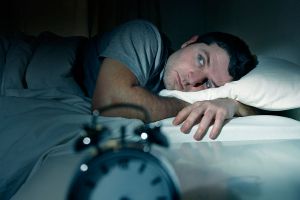 Hombre en la cama despierto, con problemas para dormir o con insomnio. Hombre en la cama despierto, con problemas para dormir o con insomnio.